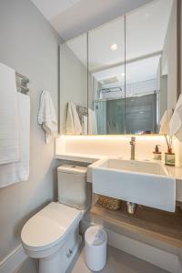 a bathroom with a toilet and a sink and a mirror at sweet ipanema Studio in Rio de Janeiro