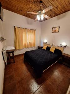 um quarto com uma cama e uma ventoinha de tecto em Hotel Vireo em Villa Gesell