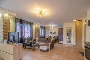 a living room with a couch and a tv at Cozy & Delightful Apart & AUBG & Free Garage Parking in Blagoevgrad