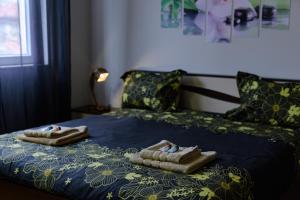 duas toalhas numa cama com um edredão azul em Cozy & Delightful Apart & AUBG & Free Garage Parking em Blagoevgrad