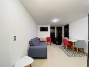 uma sala de estar com um sofá, cadeiras e uma mesa em Excepcional Apartamento -WAIWA HOST em Bucaramanga