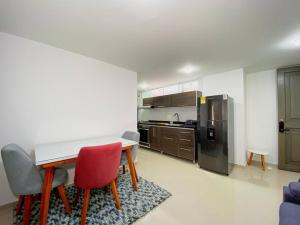cocina con mesa, sillas y nevera en Excepcional Apartamento -WAIWA HOST en Bucaramanga