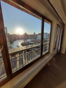 a window in a room with a view of a harbor at Marina Apartment Żuraw in Gdańsk