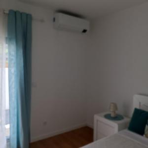 a bedroom with a bed and a blue curtain at Brava in Vila Franca do Campo