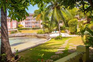 een resort met een zwembad en palmbomen bij MARIBELLA@CRYSTAL COVE OCHO RIOS in Stanmore Grove