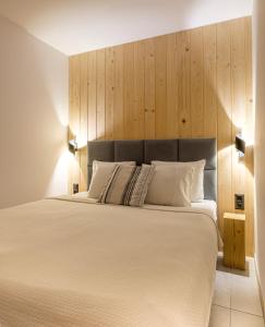 um quarto com uma cama grande e uma cabeceira em madeira em Olecka Village em Jaworzynka