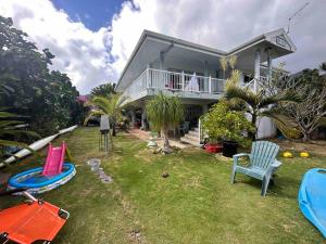 a house with a yard with chairs and a house at Meri Lodge Huahine (Mamado’s House) in Fare