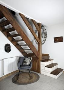 une chaise assise dans une pièce avec escalier dans l'établissement Maison Eureka Chantilly Gouvieux, à Gouvieux