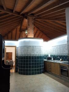 a kitchen with green tiles on the walls and a ceiling at RentalSevilla Living Villamanrique in Seville