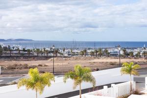 a view of a street with palm trees and the ocean at Villa Atlántica - Heated pool in Playa Blanca in Playa Blanca