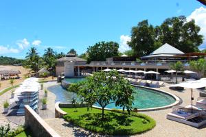 a resort pool with umbrellas and a resort at Palm Beach Resort & Spa in Ambondrona