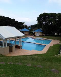 a large swimming pool with a pavilion in a yard at Caribbean Estates-Montego Bay 12 in Port Edward