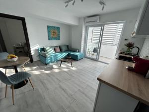 a living room with a blue couch and a table at 1 Mai - Luxury Park Apartments - Self Check-in - Private parking - 2 in Craiova