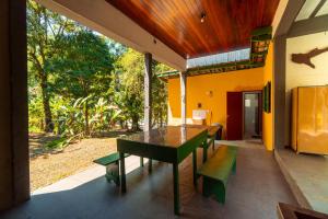 a table and benches on the porch of a house at Casa da Almada - Ubatuba - próximo a praia in Ubatuba