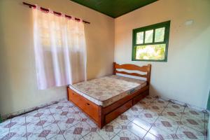 a small bedroom with a bed and a window at Casa da Almada - Ubatuba - próximo a praia in Ubatuba