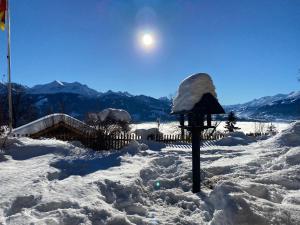 un cortile coperto di neve con la luna nel cielo di Birchihaus a Beatenberg