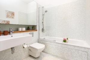 City-Centric Living Cozy 1-Bedroom Apartment في برادفورد: حمام مع مرحاض وحوض استحمام ومغسلة