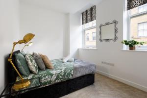 City-Centric Living Cozy 1-Bedroom Apartment في برادفورد: غرفة نوم عليها سرير ومصباح