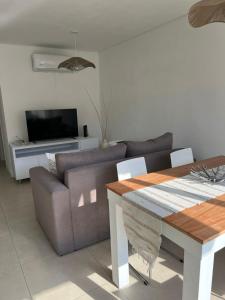 Confortable departamento en Castelar - Zona Céntrica. في Castelar: غرفة معيشة مع أريكة وطاولة