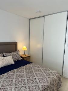 um quarto com uma cama com portas de vidro deslizantes em Confortable departamento en Castelar - Zona Céntrica. em Castelar