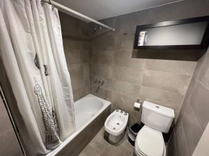 a bathroom with a toilet and a tub and a sink at Confortable departamento en Castelar - Zona Céntrica. in Castelar