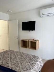 sypialnia z łóżkiem i telewizorem na ścianie w obiekcie Confortable departamento en Castelar - Zona Céntrica. w mieście Castelar
