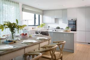 a kitchen with a table and chairs and a kitchen with white cabinets at Scots Craig in St Ives