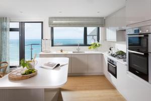 a kitchen with white cabinets and a table with a bowl of fruit at Scots Craig in St Ives