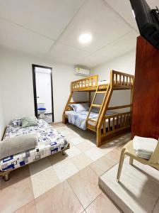 a bedroom with two bunk beds and a chair at Miss Yasmin Place in San Andrés