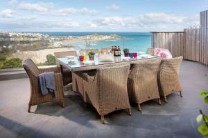 a table and chairs on a balcony with a view of the ocean at Scots Craig in St Ives