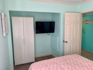 een slaapkamer met een bed en een flatscreen-tv bij The Great Escape - Panoramic Sunset views in Tampa