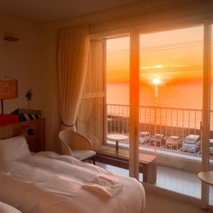 KAMOME SLOW HOTEL the COMPACT في Awaji: غرفه فندقيه بسرير وشرفه