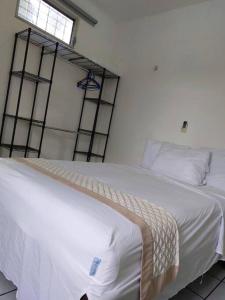 Schlafzimmer mit einem Bett mit weißer Bettwäsche und einem Fenster in der Unterkunft Estudio con terraza in Cozumel
