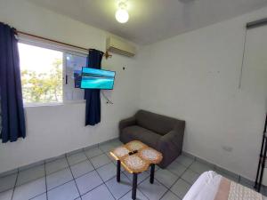 salon z kanapą, stołem i telewizorem w obiekcie Estudio con terraza w mieście Cozumel