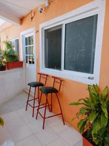 dos taburetes rojos sentados en una habitación con ventana en Estudio con terraza, en Cozumel