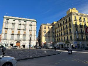 une rue urbaine avec des bâtiments et une personne à moto dans l'établissement Garibaldi guest house, à Naples