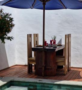 a table and chairs with an umbrella next to a pool at The Sanctuary - Private pool villas in Gili Air +36 photos
