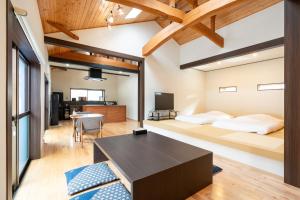 a living room with a bed and a table at Villa Miyako 源泉かけ流し客室温泉ヴィラ みやこ別邸 in Goto