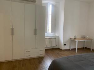 a bedroom with white cabinets and a table and a bed at Via Rivocati 108 in Cosenza