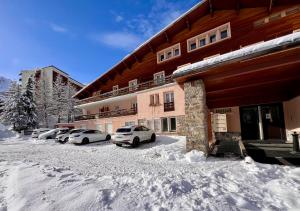 a building with cars parked in the snow at Vars, Appart spacieux rénové 4 couchages dans chalet in Vars