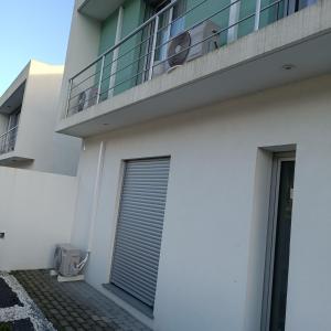 a white building with a balcony and a window at Brava in Vila Franca do Campo