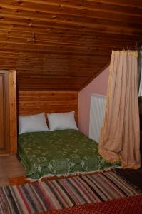 a bed in a room with a wooden ceiling at Σοφίτα in Graviá