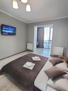 een slaapkamer met een groot bed en 2 handdoeken bij Atlant apartments in Tsjernivsi