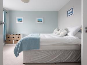a bedroom with a bed with white sheets and pillows at Llywnfor in Morfa Nefyn