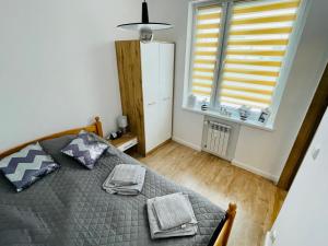 sypialnia z łóżkiem i oknem w obiekcie Mazury Szczytno - Apartamenty u Krzyżaka - Centrum w mieście Szczytno
