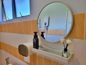 a bathroom with a round mirror and a sink at Sunway Cozy Apartment near Lost World of Tambun in Ipoh +33 photos