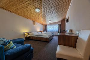 a hotel room with a bed and a couch at Grand Hotel rooms in Spišské Tomášovce