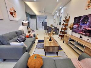 uma sala de estar com dois sofás e uma televisão em Sunway Cozy Apartment near Lost World of Tambun em Ipoh