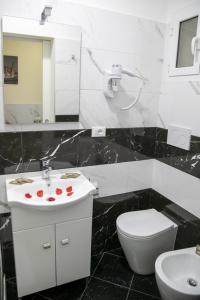 a black and white bathroom with a toilet and a sink at NINFA in Rome