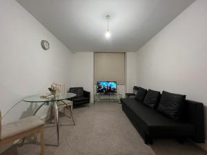 a living room with a black couch and a table at Entire Flat near Kings Cross in London